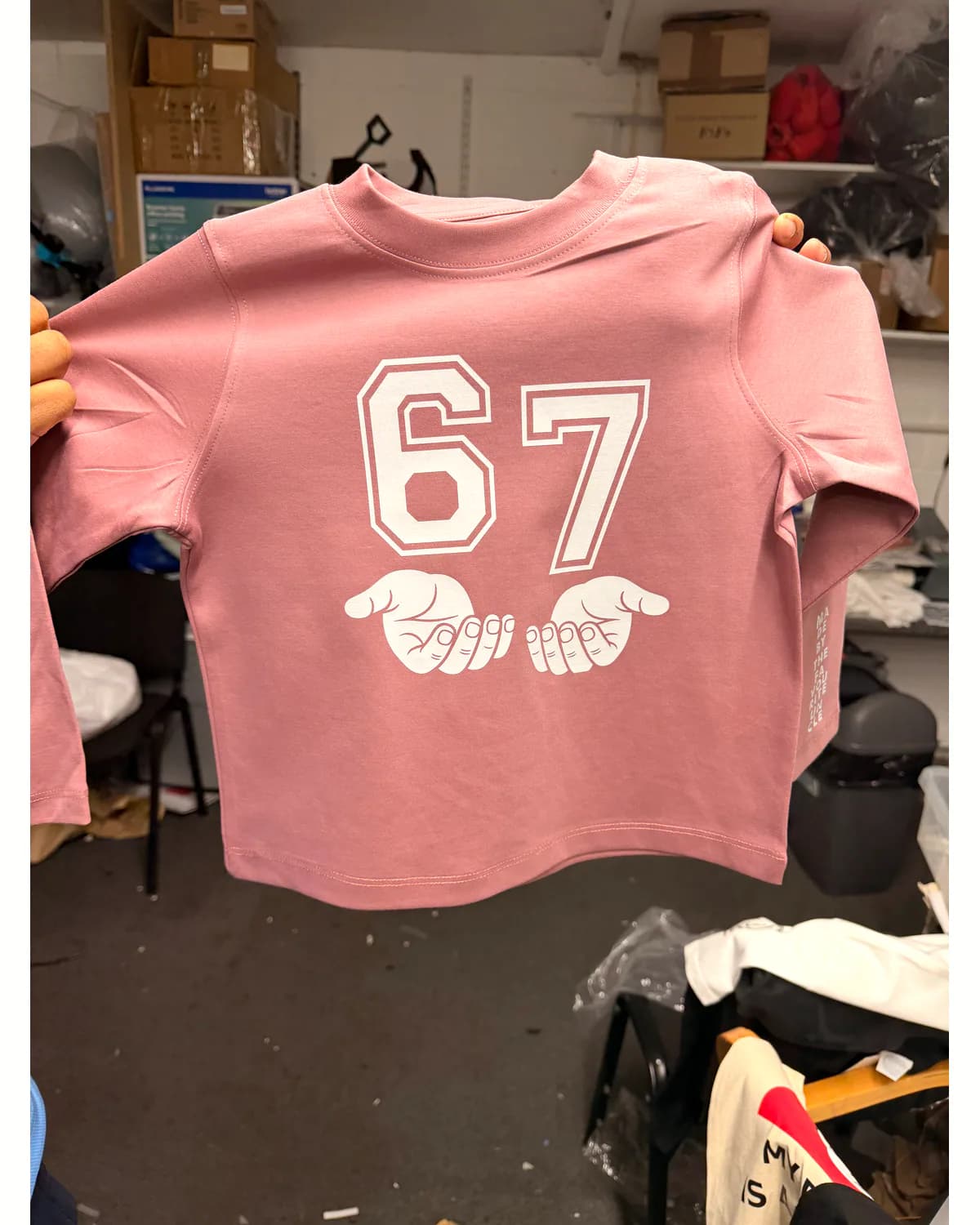 Pink T shirt with a large white number and small graphic on the back