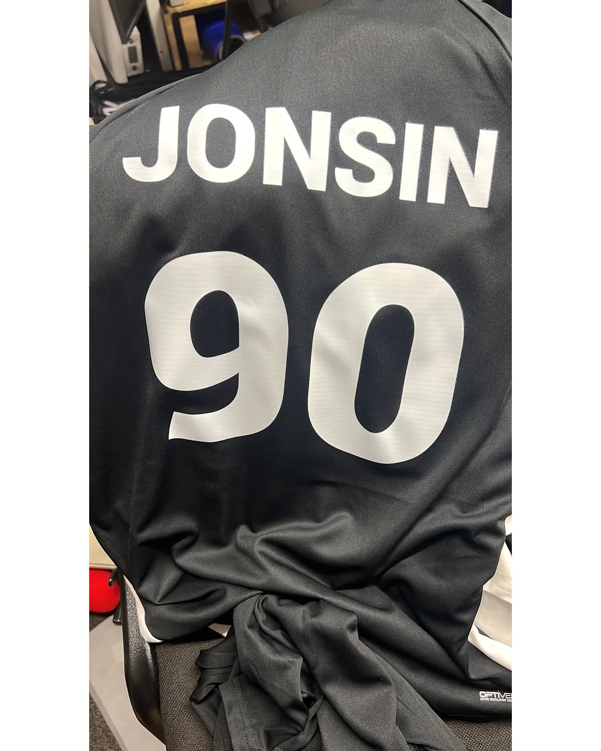 Black sports shirt with a white personalised name and number 90