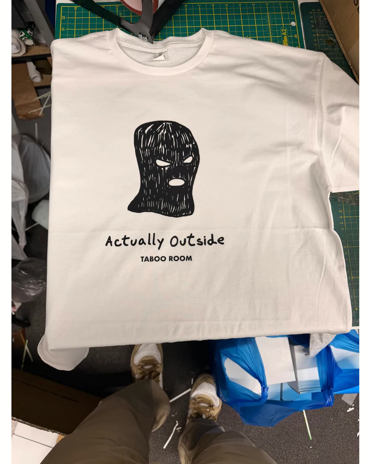 White T shirt with a simple black graphic and small wording