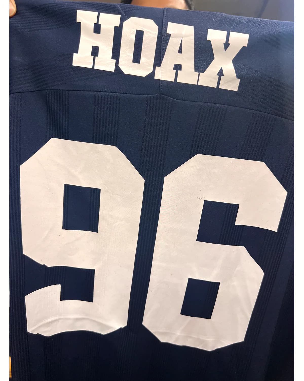 Navy sports shirt with a white varsity name and number 96