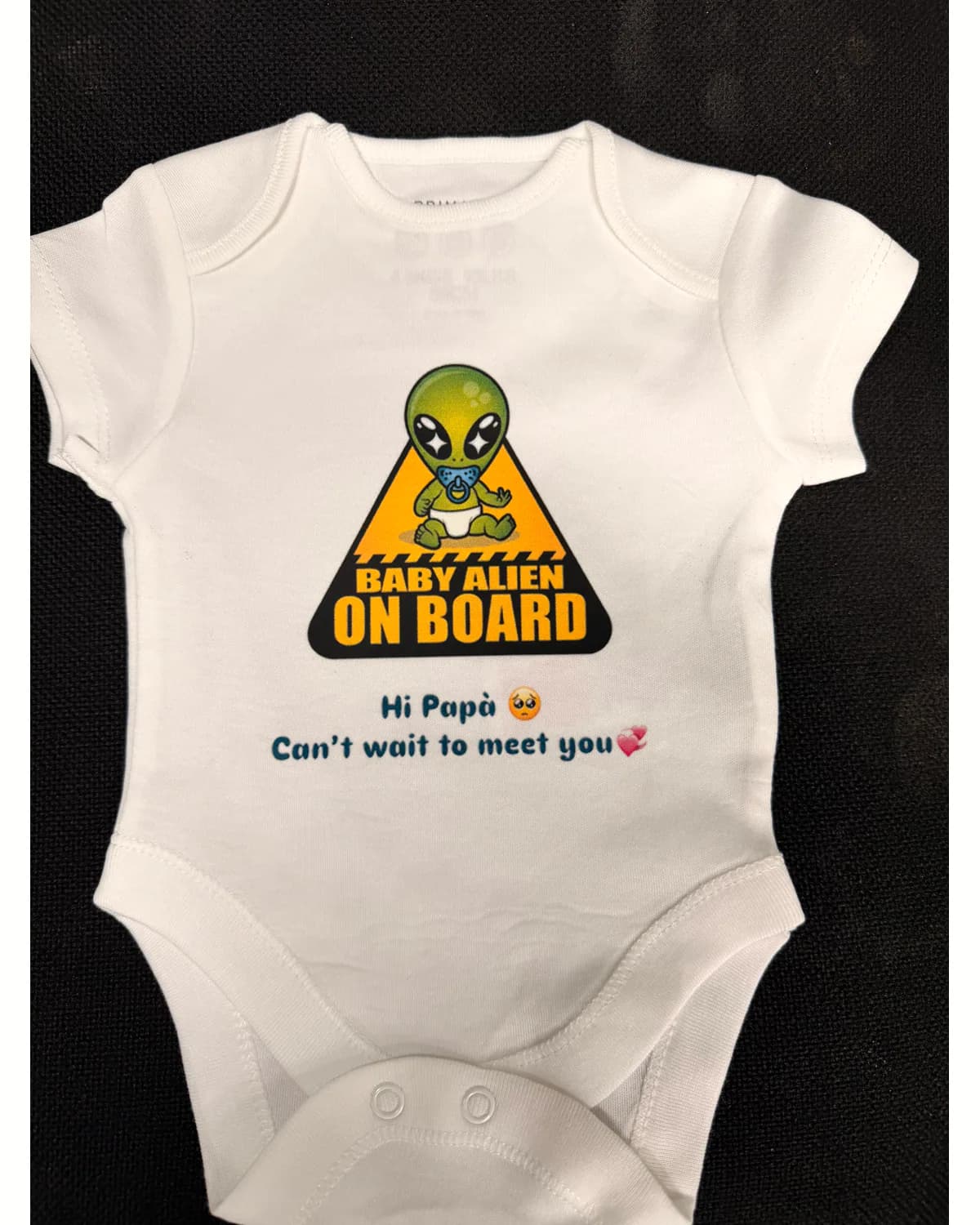 White personalised baby vest with a colourful announcement design