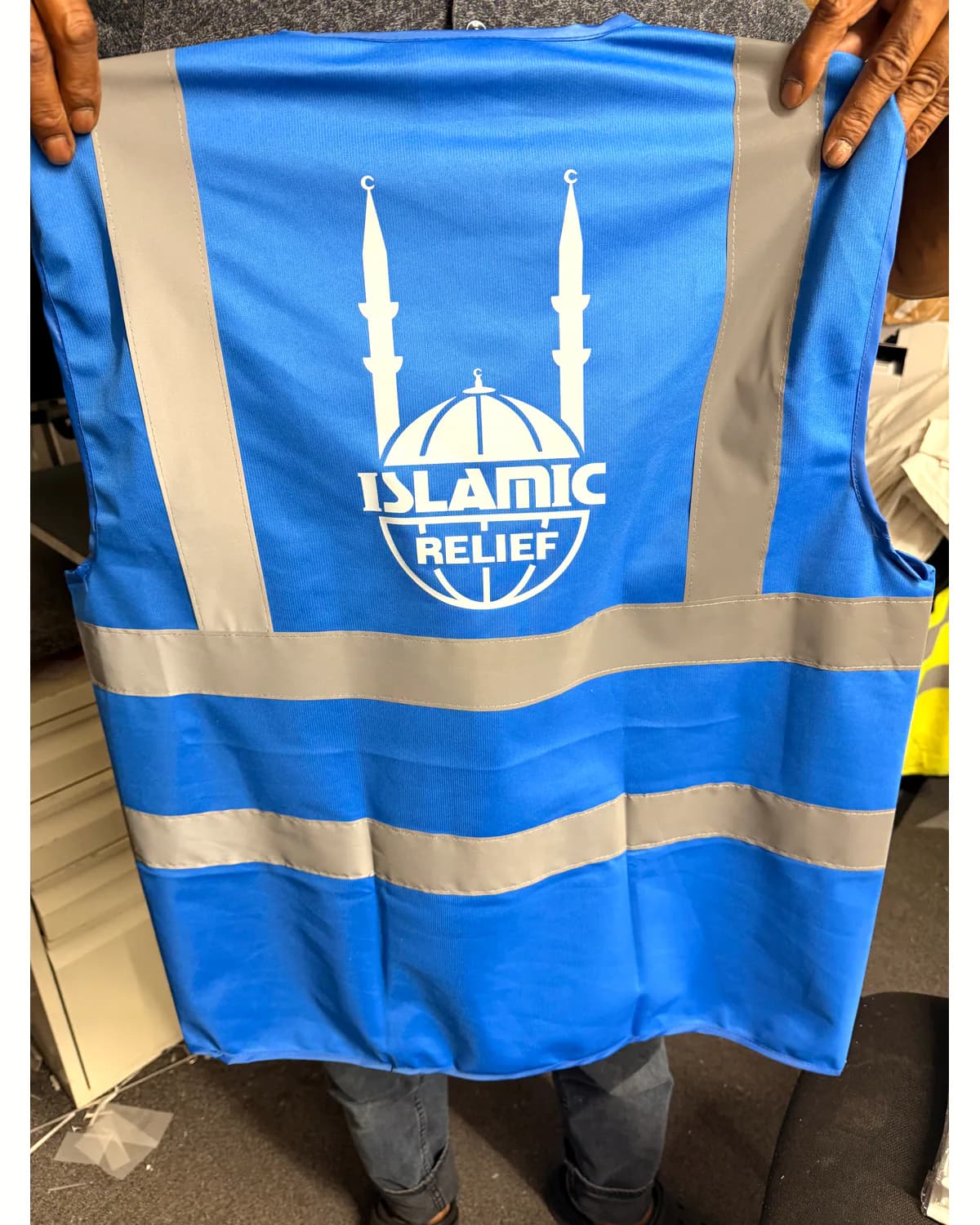 Blue hi-vis vest with reflective strips and a white custom organisation logo