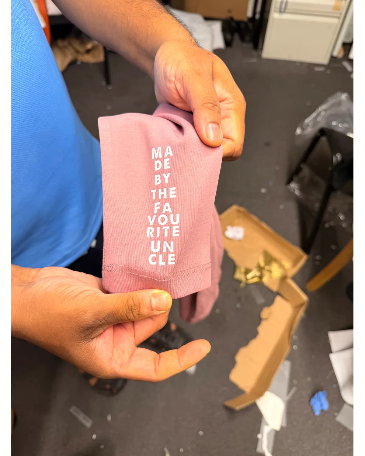 Close-up of a custom white vertical print on a pink T shirt sleeve
